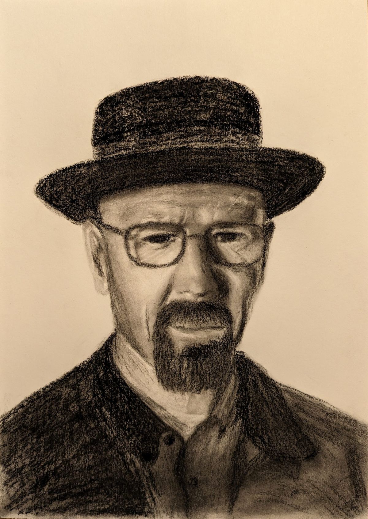 Charcoal drawing on paper: a man in a wide-brimmed hat and glasses with a goatee, looking straight ahead